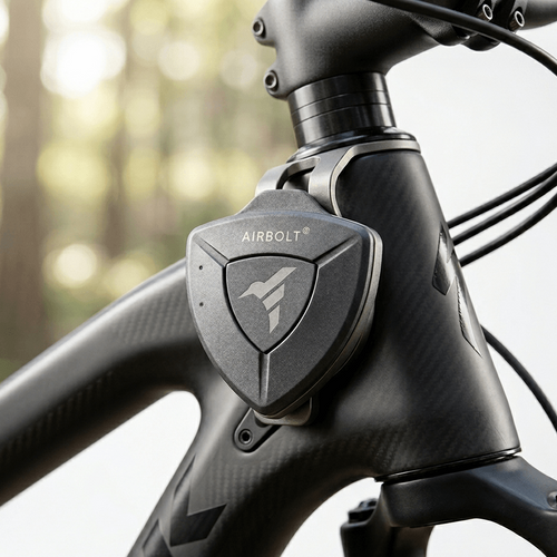 Close-up of a bicycle handlebar with AIRBOLT logo against a blurred forest background